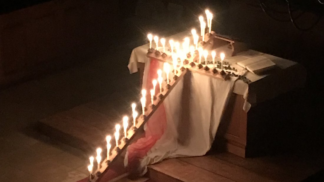 mit Kerzen beleuchtetes Osterkreuz
