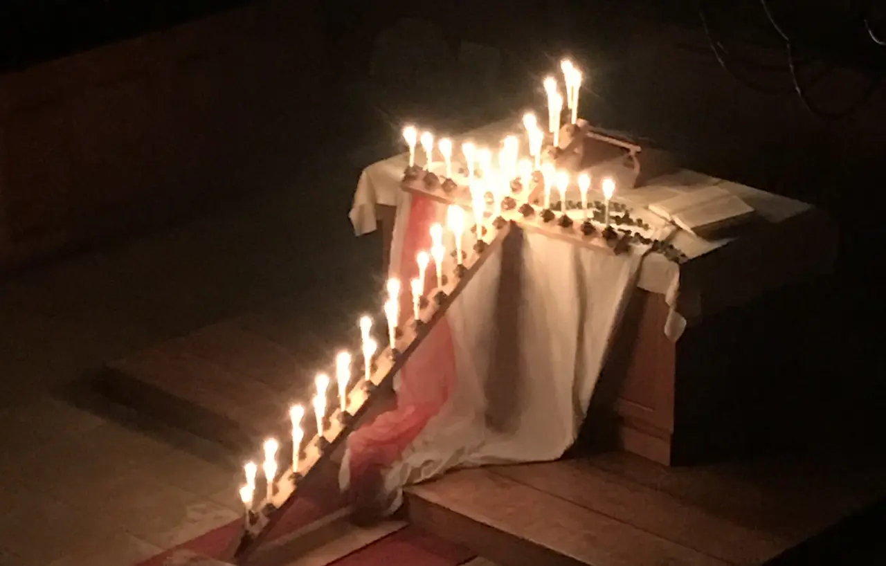 mit Kerzen beleuchtetes Osterkreuz